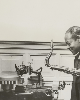 Amerikaans jazzmusicus en saxofonist Coleman Hawkins beluistert een zojuist gemaakte grammofoonopname, 1935. Fotograaf onbekend/Vereenigde Fotobureax, Collectie Nationaal Archief.