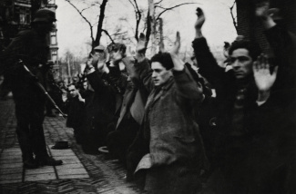 Geknielde Joden worden onder schot gehouden tijdens de razzia in Amsterdam (februari 1941).